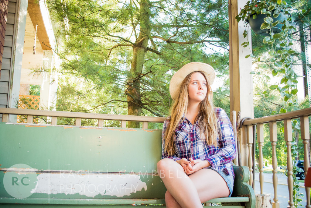 Senior portrait of a young woman wearing a cowboy hat sitting on a bench in Solon Ohio