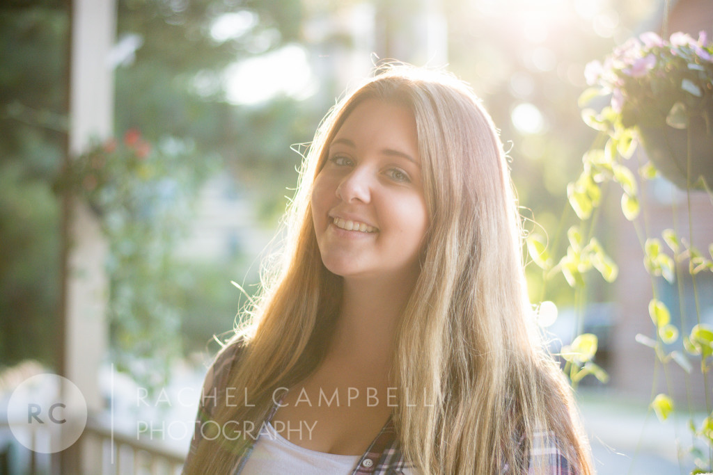 Senior portrait of a young woman at sunset standing in front of flowers in Solon Ohio