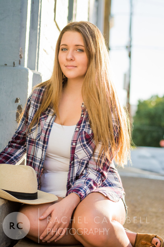 Senior portrait of a young woman sitting near a wall in Solon Ohio