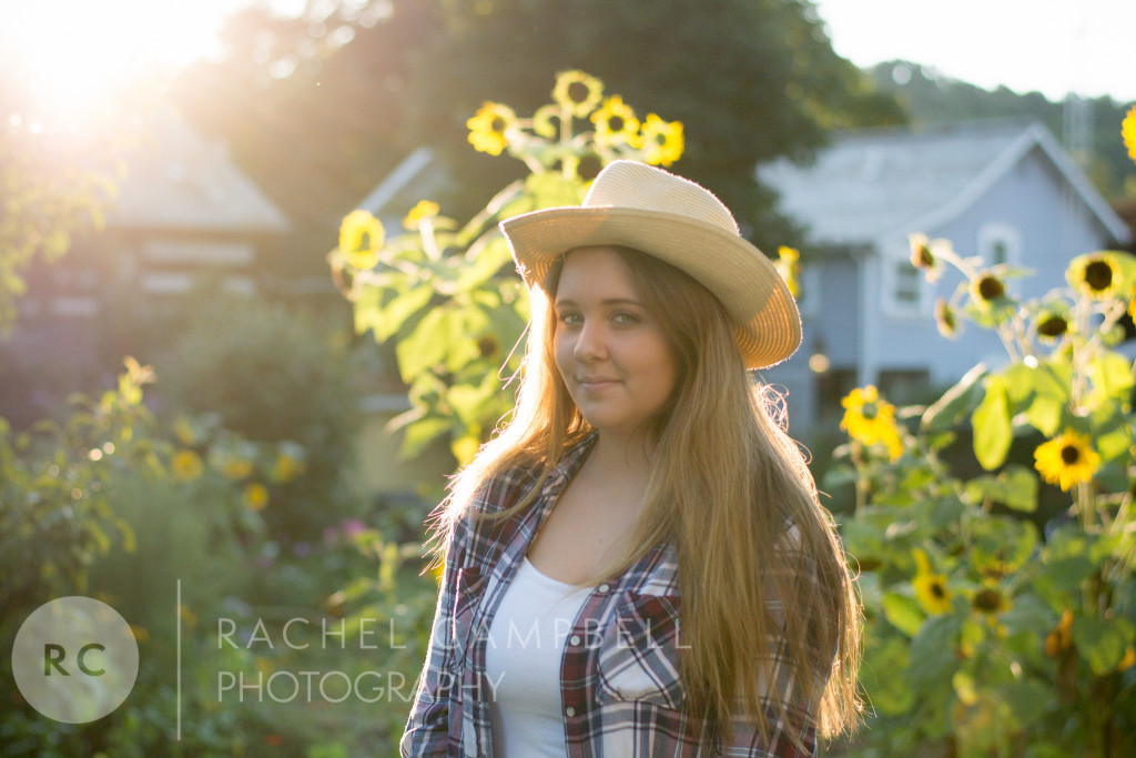 Senior portrait of a young woman at sunset standing in front of sunflowers in Solon Ohio