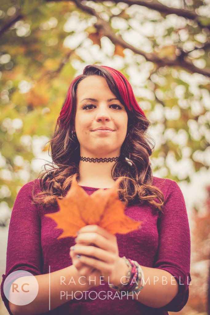 Senior portrait of a young woman holding a leaf in a park in Solon Ohio