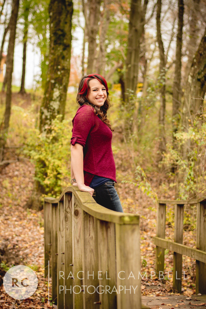 Senior portrait of a young woman leaning on a bridge in the woods in Solon Ohio