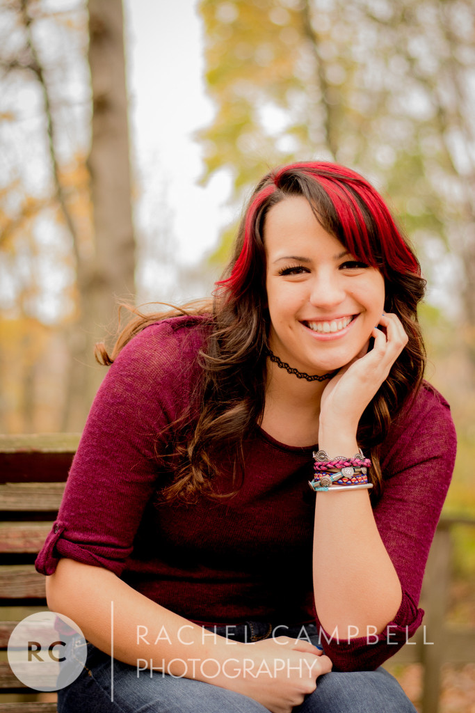 Senior photo of a young woman sitting on a bench in a park in Solon Ohio