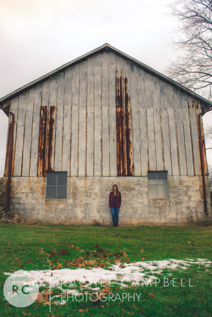 Senior portrait of a young woman leaning against a barn in Solon Ohio