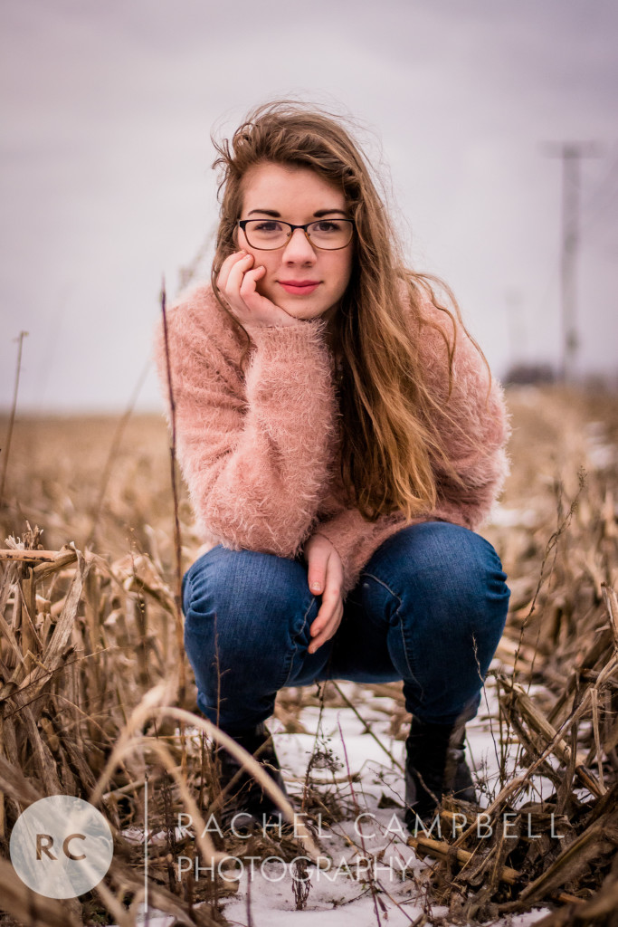 Senior portrait of a young woman in a cornfield in winter in Solon Ohio