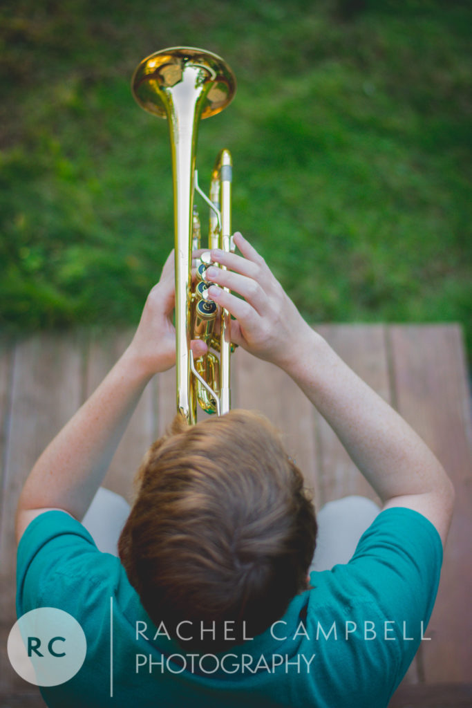 Senior picture of a young man playing his trumpet
