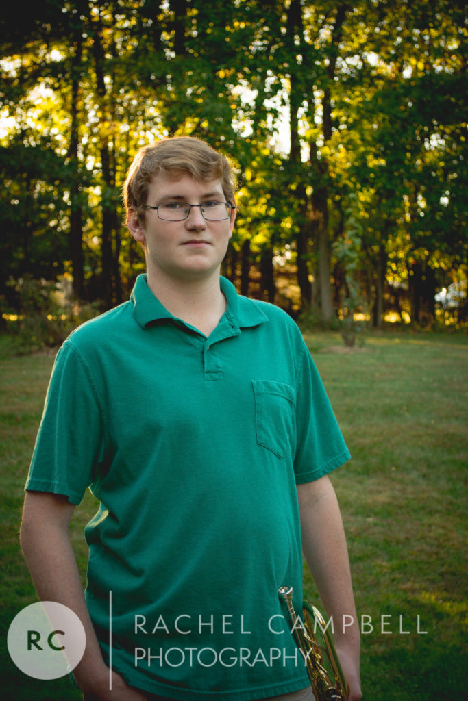 Senior portrait of a young man in a field at sunset in Solon Ohio