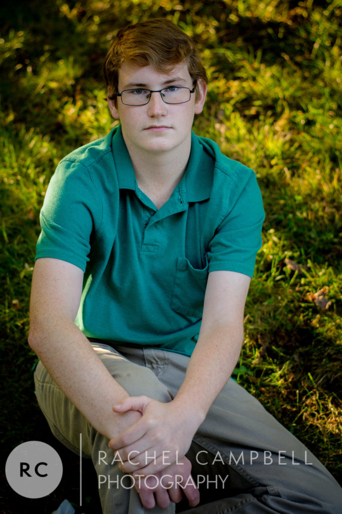 Senior picture of a young man sitting in grass in Solon Ohio