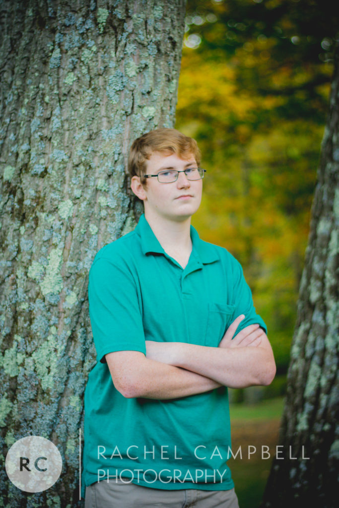 Senior portrait of a young man leaning against a tree in Solon Ohio