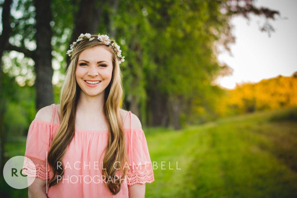 Senior portrait of a young woman laughing in a field at sunset in Solon Ohio