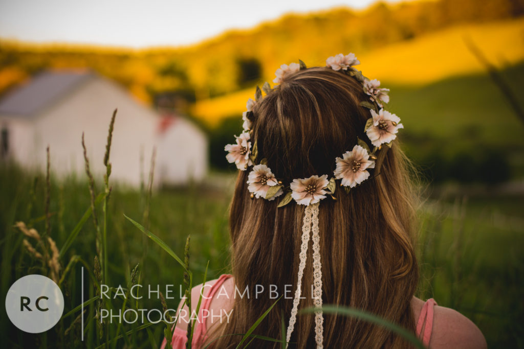 Senior portrait of a young woman facing away from the camera wearing a flower crown at sunset in Solon Ohio