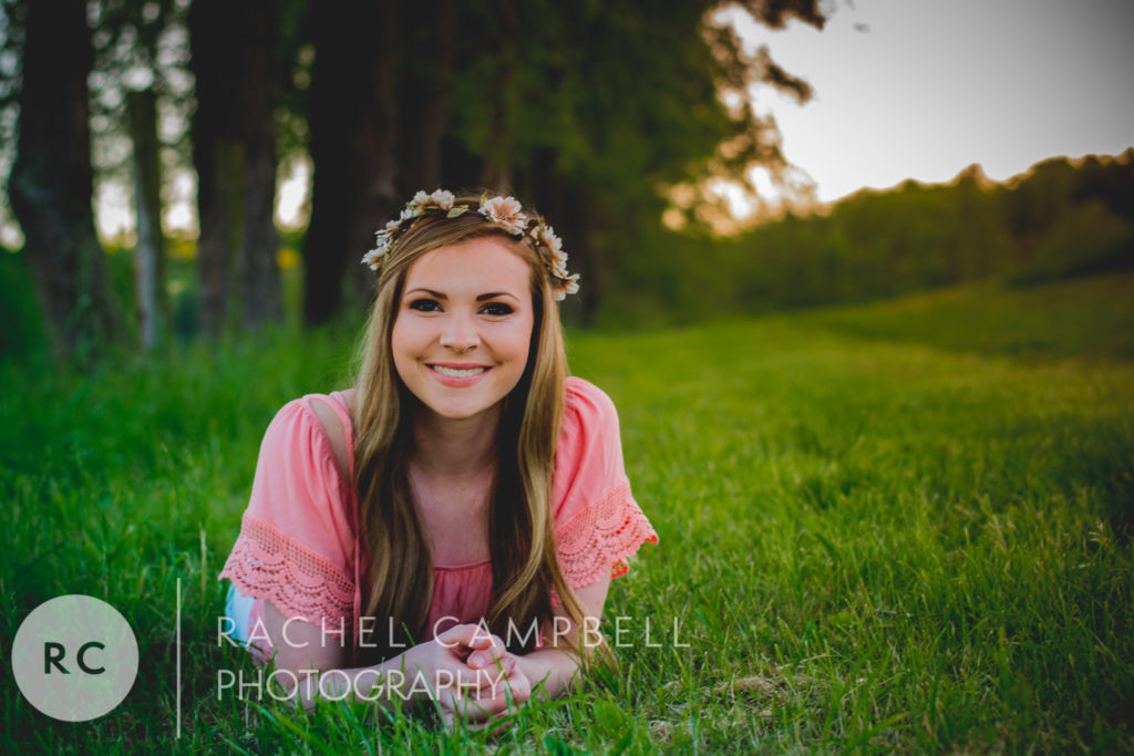 Senior portrait of a young woman laying in grass at sunset in Solon Ohio