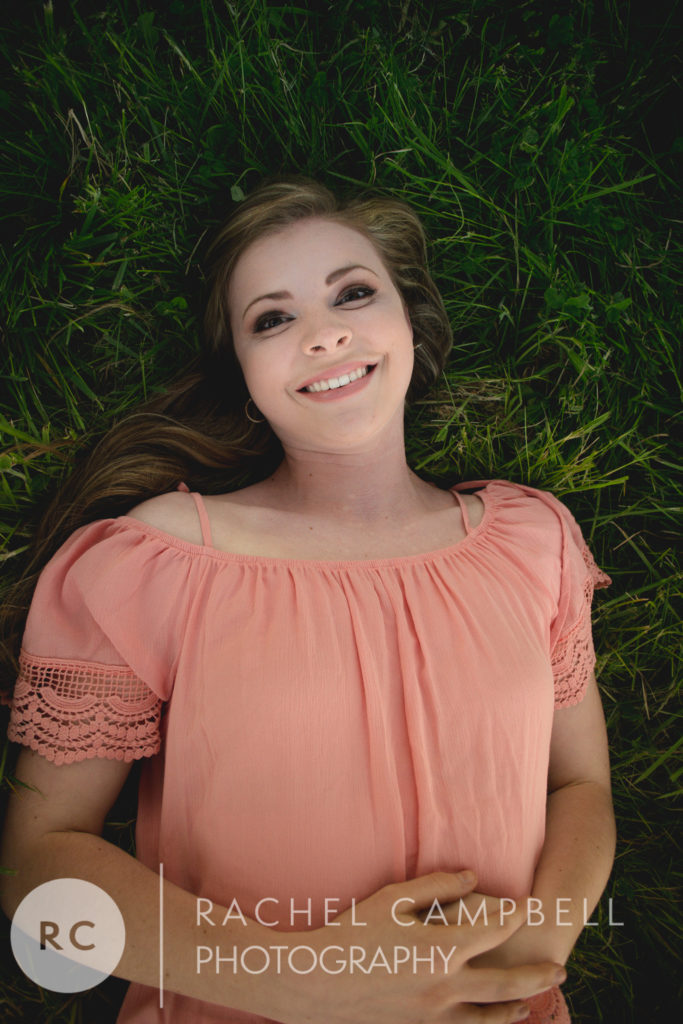 Senior portrait of a young woman laying in grass in Solon Ohio