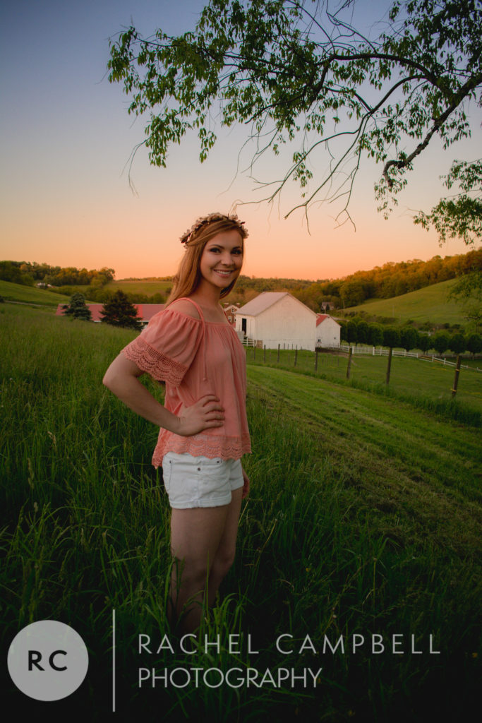 Senior portrait of a young woman standing in a field at sunset in Solon Ohio