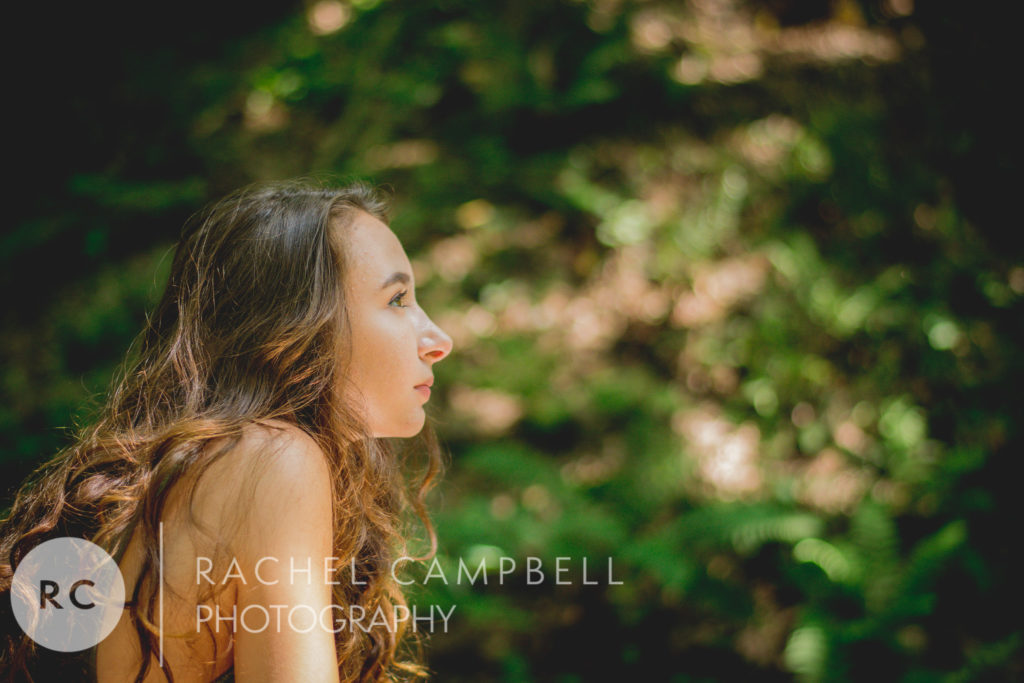 Senior portrait of a young woman looking out at the trees in the woods in Solon Ohio.