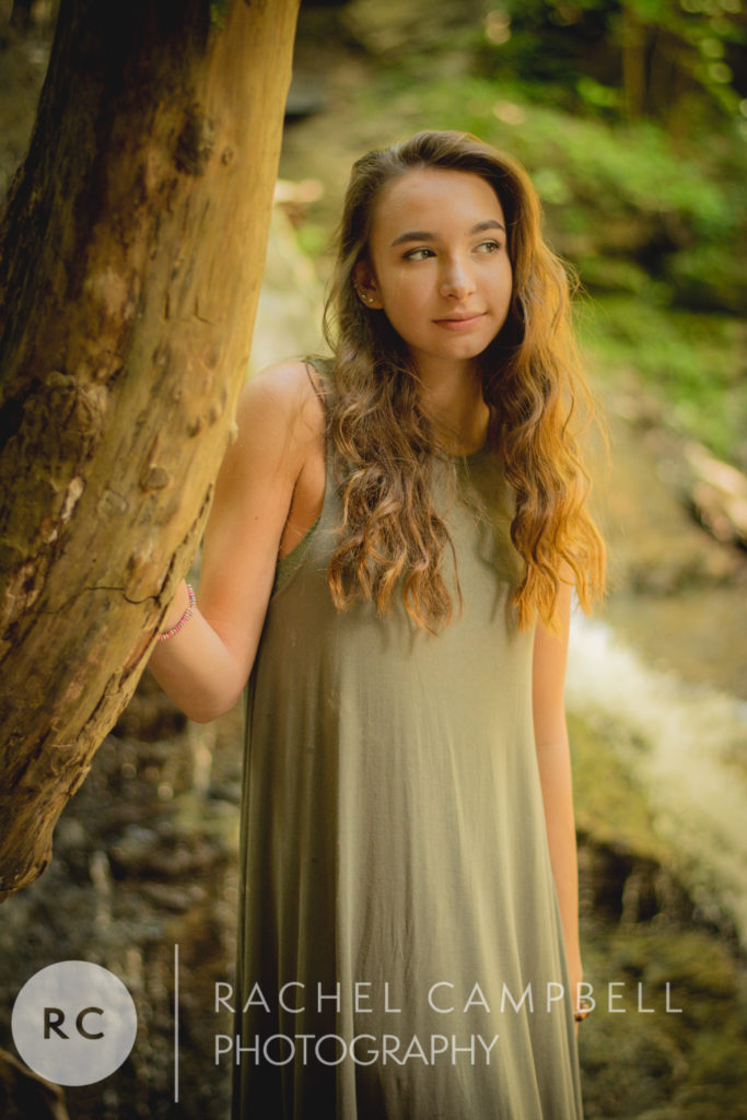 Senior portrait of a young woman leaning on a tree in the woods in Solon Ohio