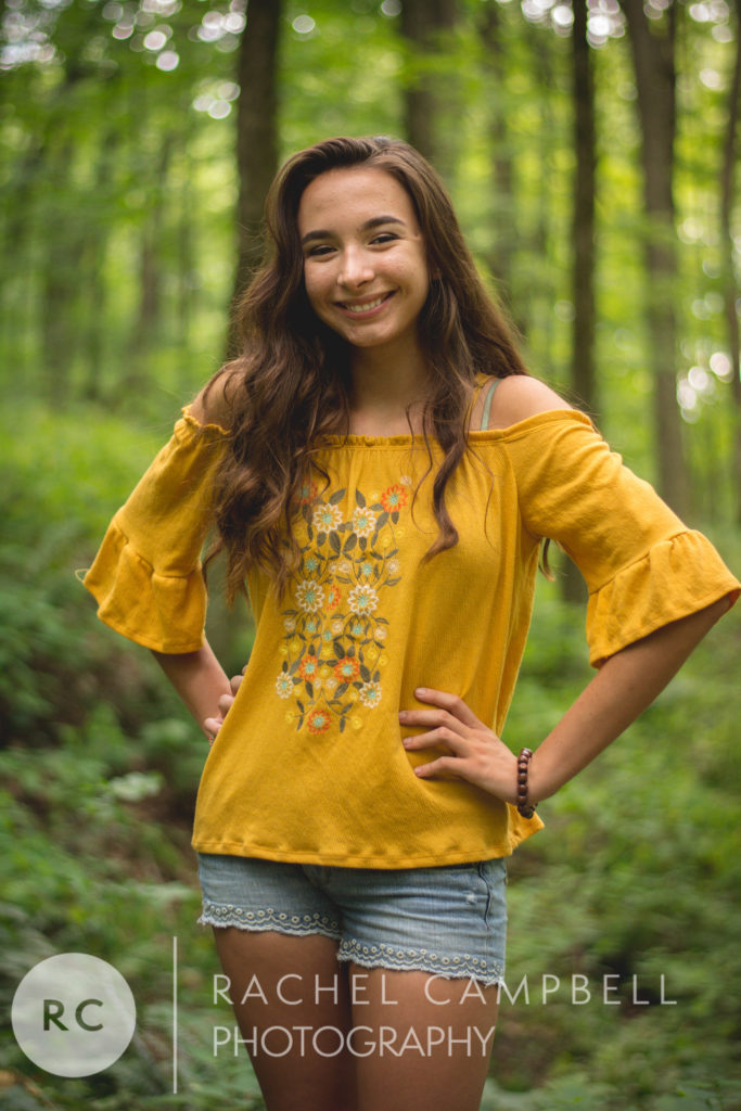 Senior portrait of a young woman standing in the woods in Solon Ohio