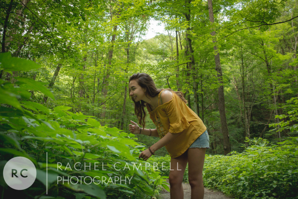 Senior photo of a woman smiling while looking at plants in Solon Ohio