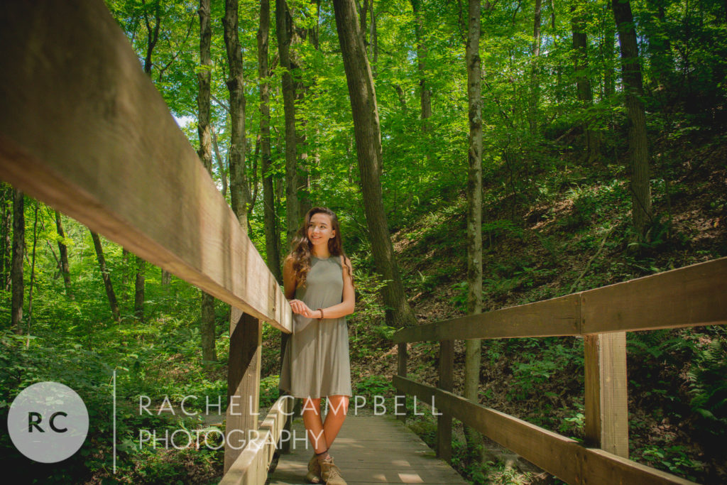 Senior portrait of a young lady standing on a bridge in the woods in Solon Ohio