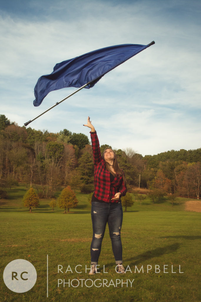 Senior portrait of a young woman throwing a flag during a color guard routine near Solon Ohio