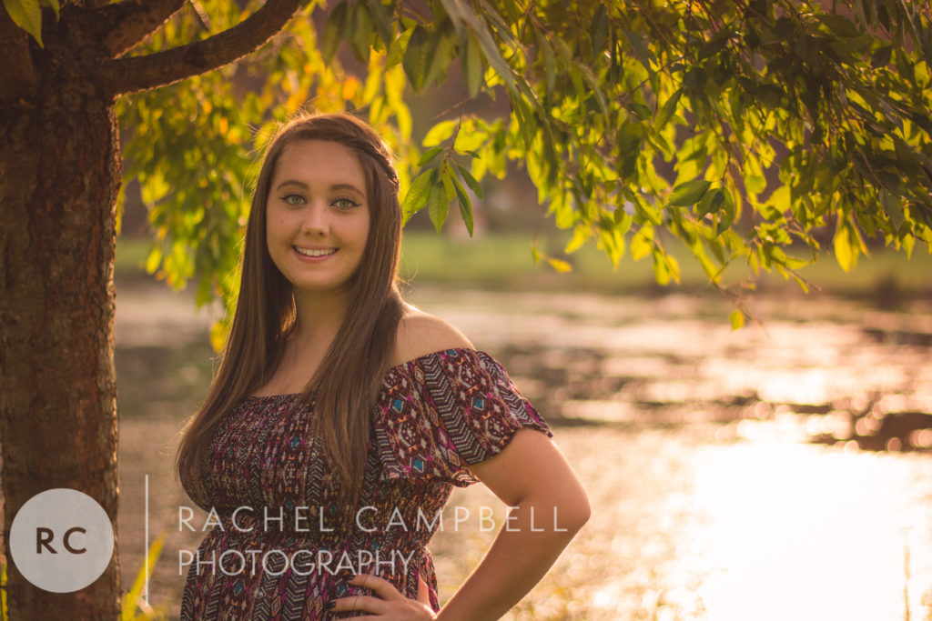 Senior photo showing a young woman under a tree at sunset in Solon Ohio