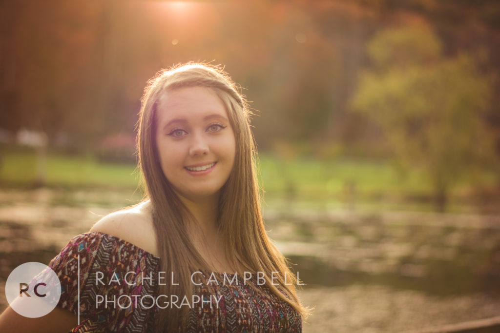 Senior photo of a young woman in front of a pond at sunset in Solon Ohio