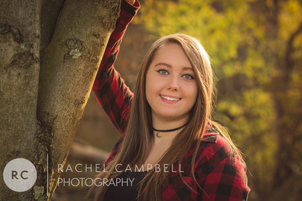 Senior portrait of a young woman leaning on a tree at sunset in Solon Ohio