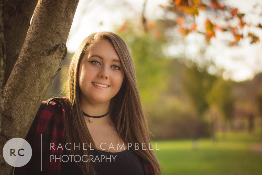 Senior portrait of a young woman underneath a tree at sunset in Solon Ohio